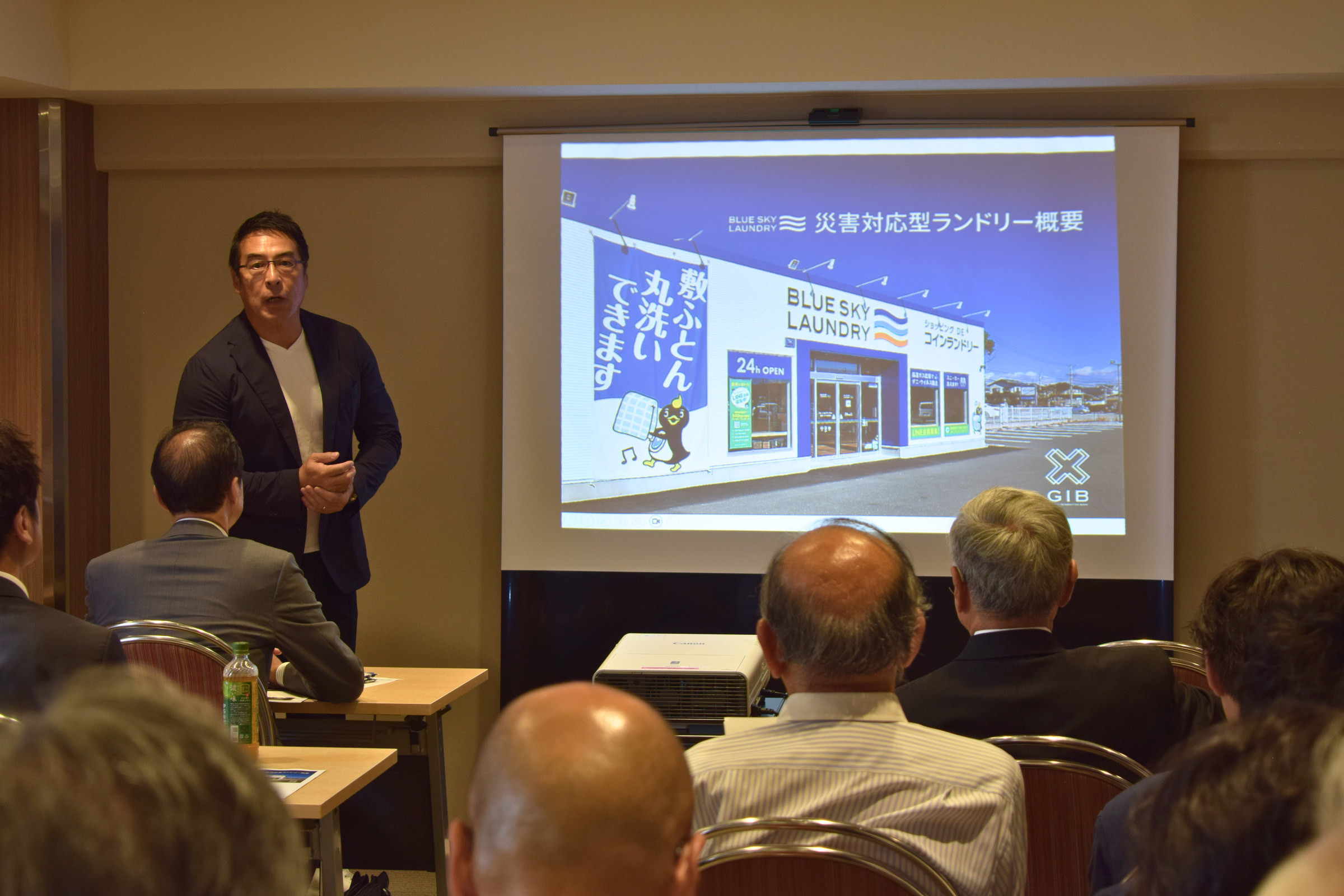 災害対応型ランドリーの取り組みを説明する株式会社ジーアイビーの鈴木衛代表取締役